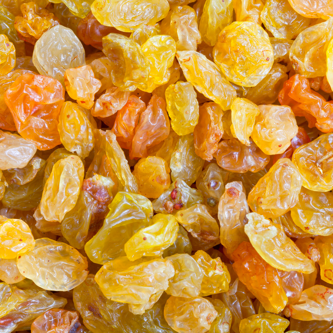 Close-up of fresh, plump raisins in a white bowl.