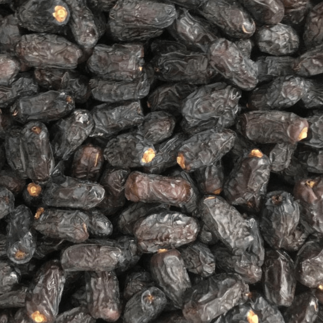 Qalmi Dates spread out in a cart, highlighting their distinctive wrinkled appearance